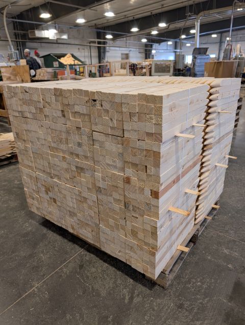 Bundled wood stakes stacked on the shop floor.
